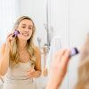 Person trägt einen INUANA Kosmetik Stick als innovative Gesichtspflege auf ihre Wangen auf.