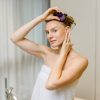 Frau im Handtuch trägt den violetten Haarwachs Stick von INUANA am Haaransatz auf.