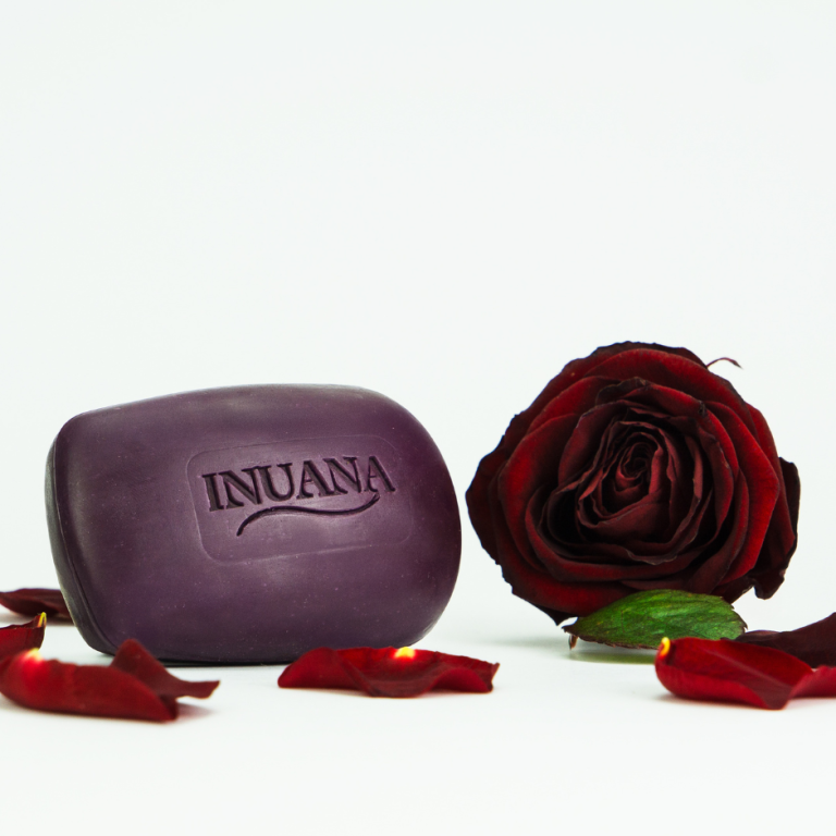 Dunkellila Seife von INUANA mit eingeprägtem Markenlogo neben einer dunkelroten Rose auf weißem Hintergrund.