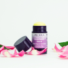 INUANA Gesichtsöl Stick Golden Argan & Velvet Rose umgeben von frischen Rosenblättern auf weißem Hintergrund.