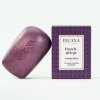 Lila INUANA Duschpflege-Stück Violette Noire für die Körperpflege neben der gemusterten Produktverpackung.