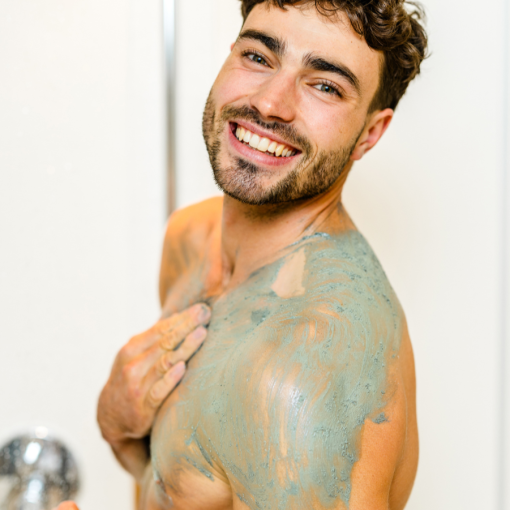 Lachender Mann trägt INUANA 3in1-Shower Mousse Signature auf Schulter und Brust auf