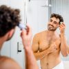 Lächelnder Mann trägt den Haarwax Stick Signature als Kosmetik Stick von INUANA auf sein Haar auf