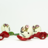 Drei runde INUANA Badekugel mit Rosenblüten als natürlicher Badezusatz umgeben von roten Blütenblättern