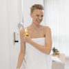 Lächelnte Frau im Handtuch hält den After Sun Stick von INUANA im Badezimmer.
