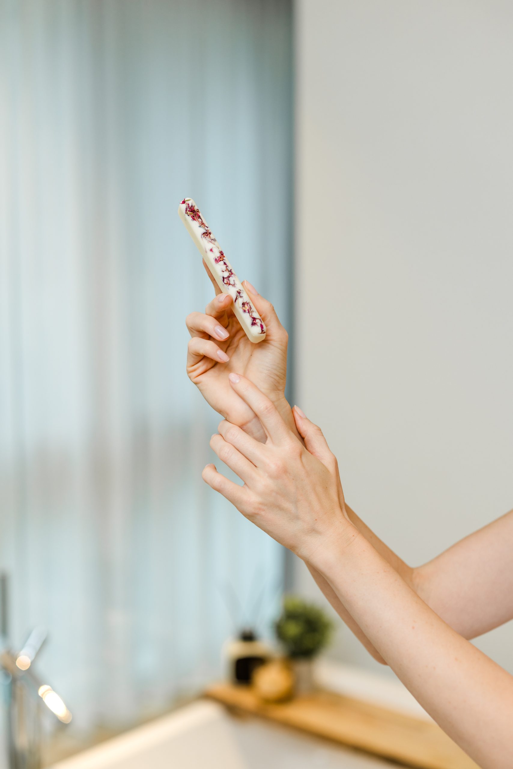 Person trägt den Badestick Violette Noire von INUANA für wohltuende Körperpflege auf das Handgelenk auf