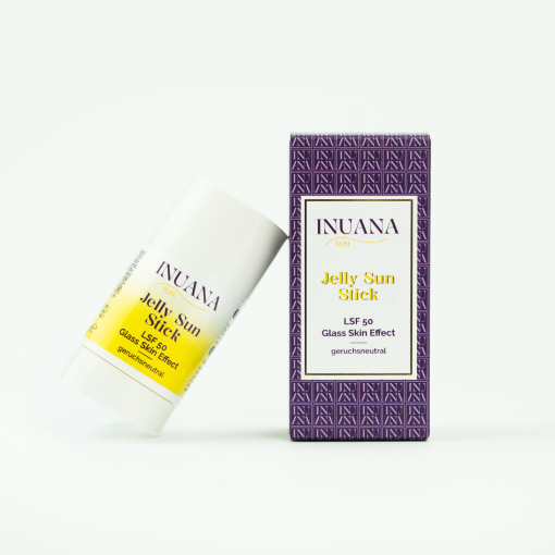 INUANA SUN Jelly Sun Stick LSF 50 im weißen Kosmetik Stick neben der violett gemusterten Karton-Verpackung.