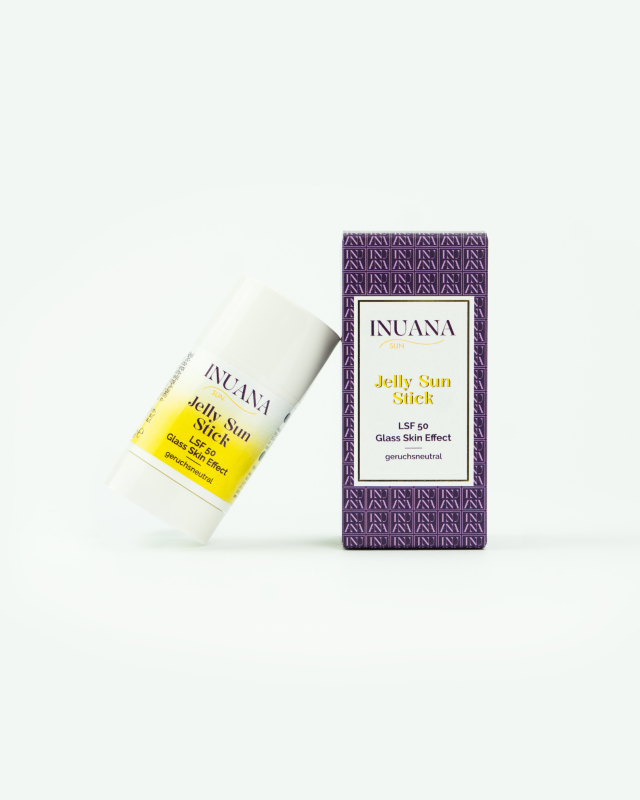 INUANA SUN Jelly Sun Stick LSF 50 im weißen Kosmetik Stick neben der violett gemusterten Karton-Verpackung.