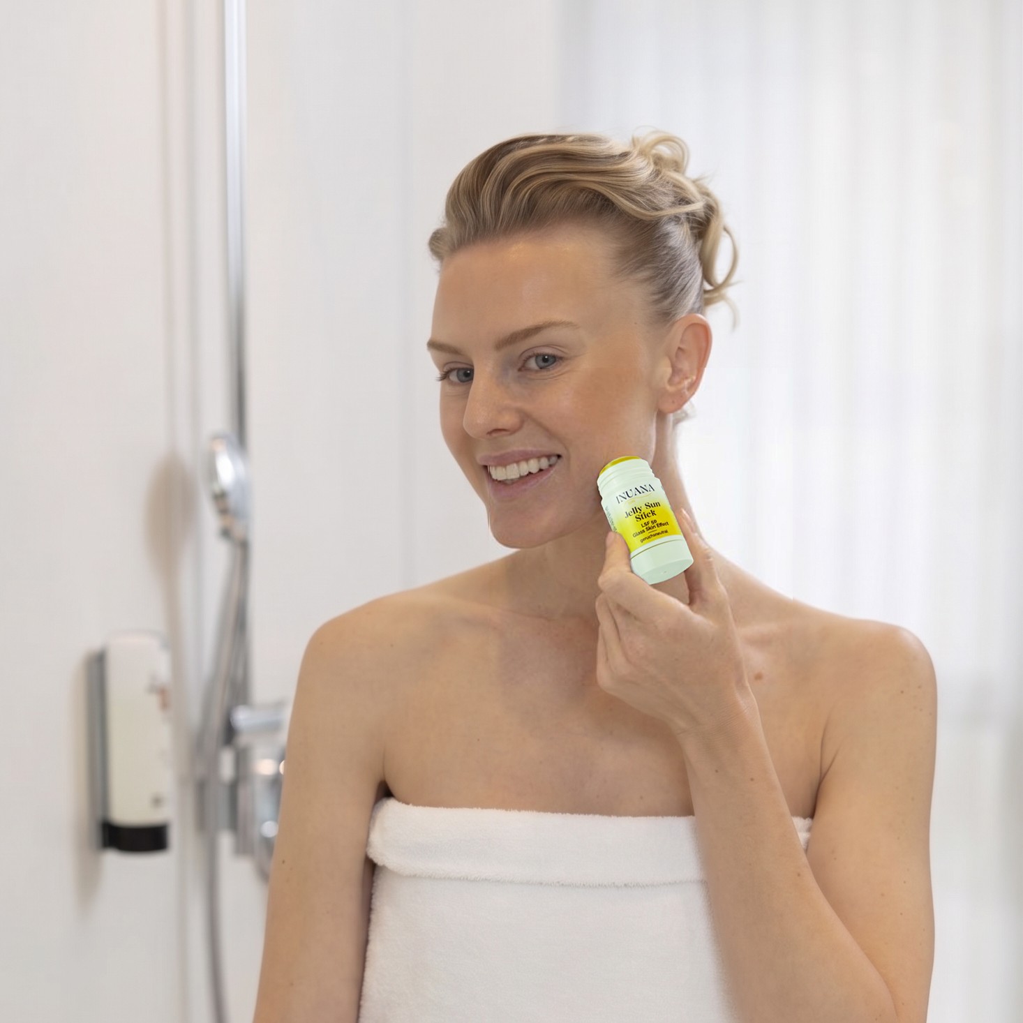 Lächelnde Person trägt den INUANA Jelly Sun Stick als schützende Gesichtspflege auf die Wange auf.